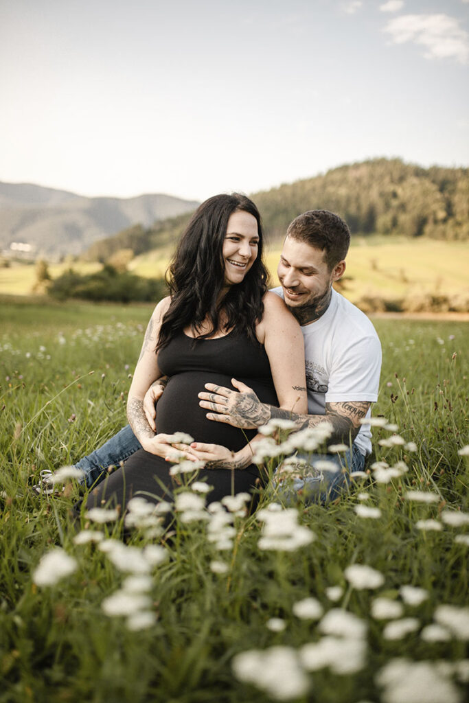 Schwangerschaftsfotoshooting in einer Wildblumenwiese bei Wiener Neustadt, Paar genießt die Zeit.