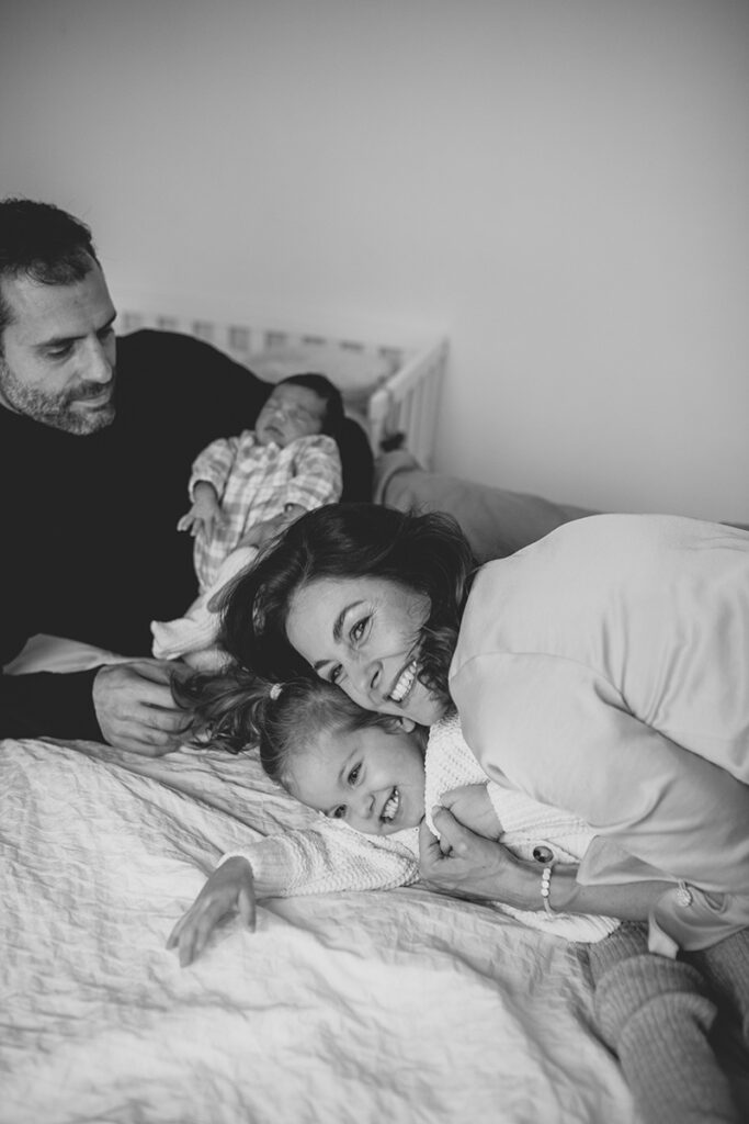 Schlafendes Baby auf Papas Arm im Wochenbett – Familienmoment beim Neugeborenen Shooting Zuhause in NÖ
